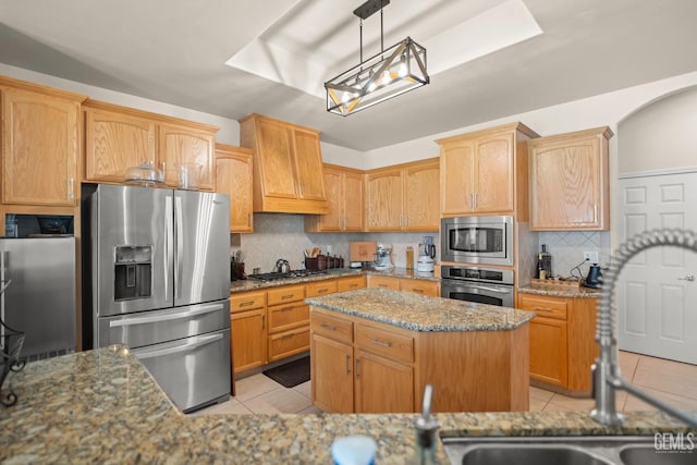 kitchen featuring a center island, light tile patterned floors, stone counters, stainless steel appliances, and backsplash