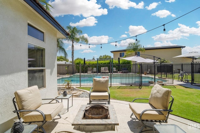 view of patio with a fenced in pool and a fire pit