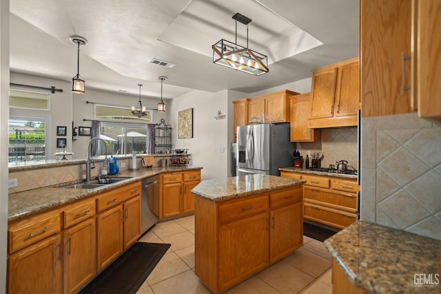 kitchen with pendant lighting, sink, a kitchen island, and appliances with stainless steel finishes