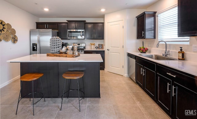 kitchen featuring sink, a kitchen breakfast bar, a center island, and appliances with stainless steel finishes