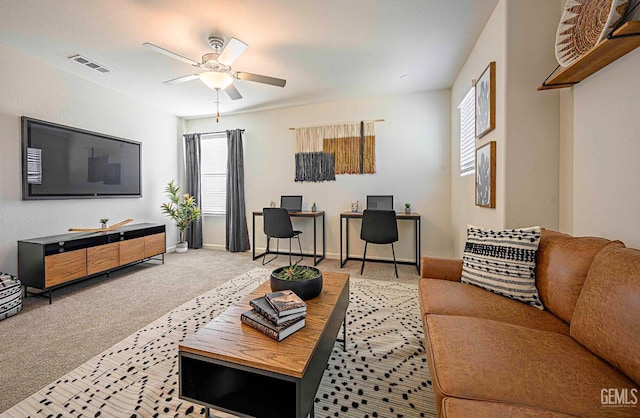 carpeted living room with ceiling fan