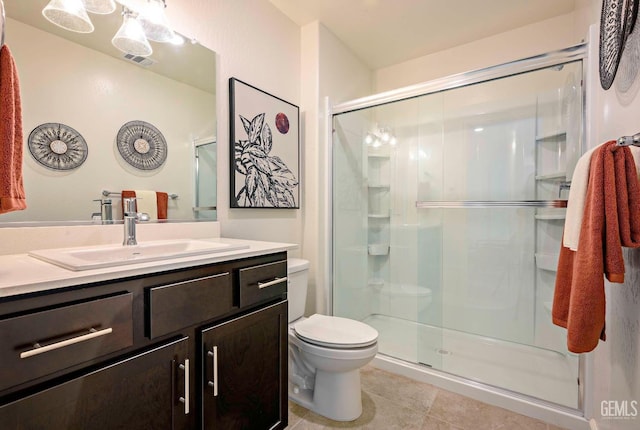 bathroom featuring an enclosed shower, vanity, tile patterned floors, and toilet