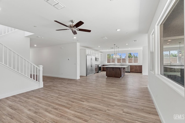6501 Thunder Trail Dr, Bakersfield, CA 93313 - kitchen with stainless steel appliances, open floor plan, a center island, light wood-style flooring, and a ceiling fan