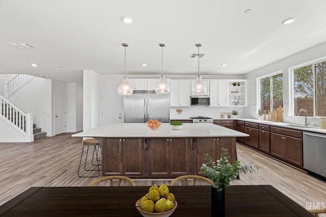 6501 Thunder Trail Dr, Bakersfield, CA 93313 - kitchen featuring appliances with stainless steel finishes, a center island, open shelves, backsplash, and light countertops