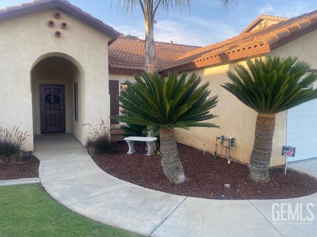 11422 Pacific Harbor Ave, Bakersfield, CA 93312 - doorway to property with stucco siding and a tiled roof