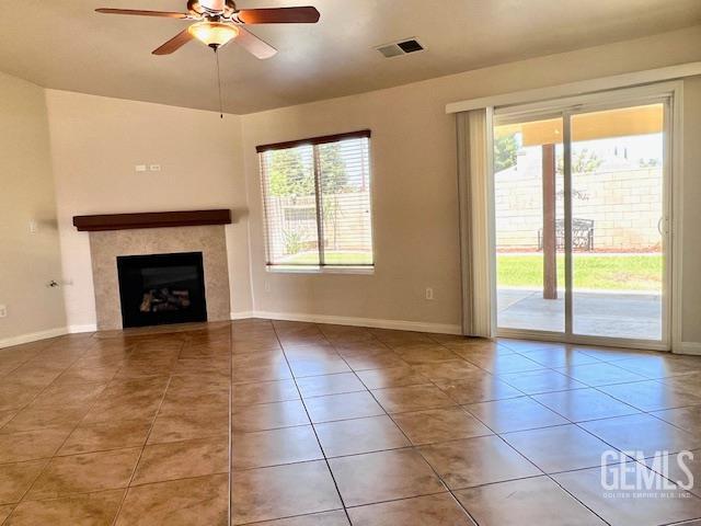 11422 Pacific Harbor Ave, Bakersfield, CA 93312 - unfurnished living room featuring tile patterned floors, ceiling fan, and a tiled fireplace