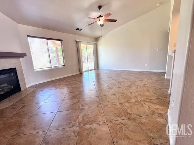 11422 Pacific Harbor Ave, Bakersfield, CA 93312 - unfurnished living room with lofted ceiling, a ceiling fan, a fireplace, and tile patterned flooring