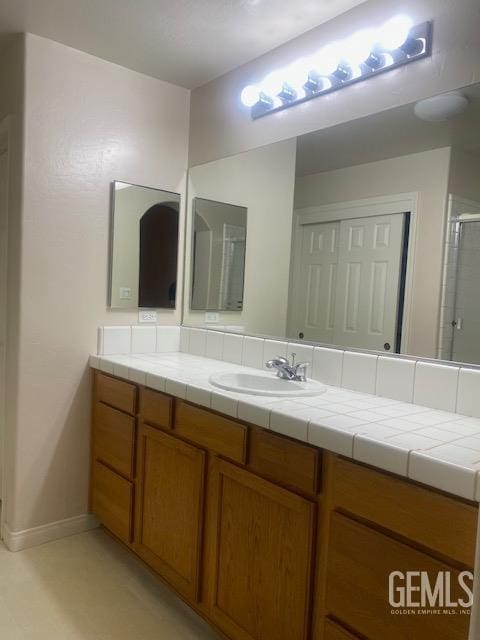 11422 Pacific Harbor Ave, Bakersfield, CA 93312 - bathroom featuring vanity, baseboards, and a shower with shower door