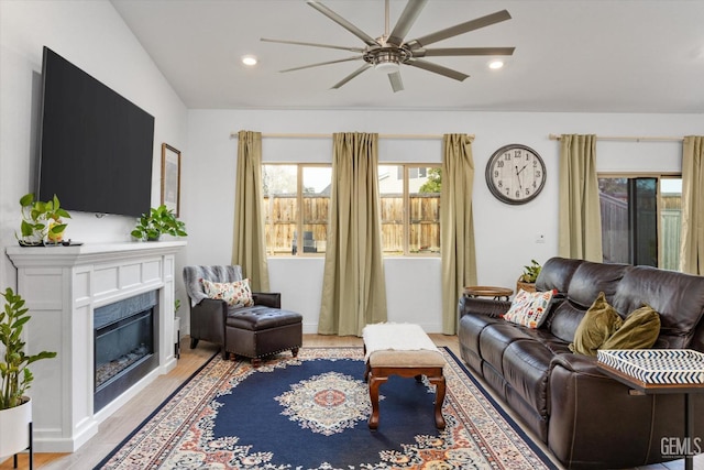 living area with light wood-style flooring, a fireplace, a ceiling fan, and recessed lighting