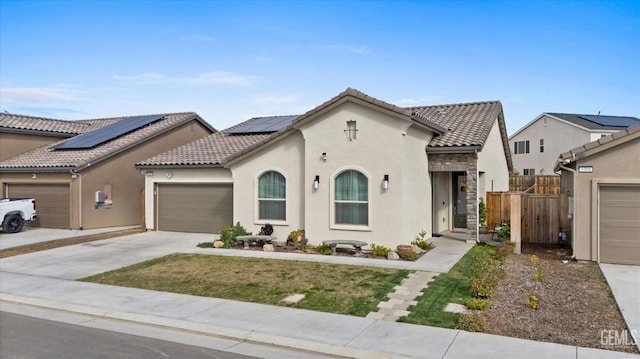 mediterranean / spanish house featuring driveway, a garage, fence, and stucco siding