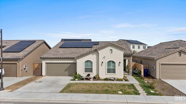 view of front of property featuring an attached garage, solar panels, a tiled roof, driveway, and stucco siding