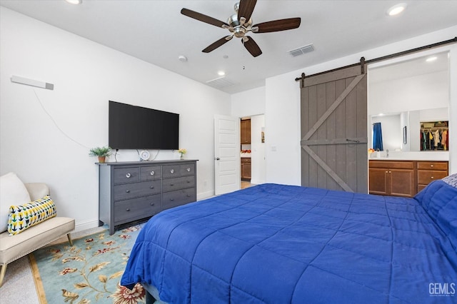 bedroom with carpet floors, recessed lighting, visible vents, a barn door, and connected bathroom