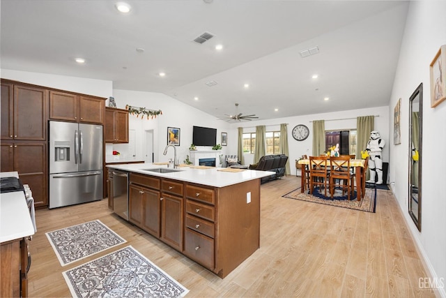 kitchen featuring visible vents, lofted ceiling, appliances with stainless steel finishes, light countertops, and a sink