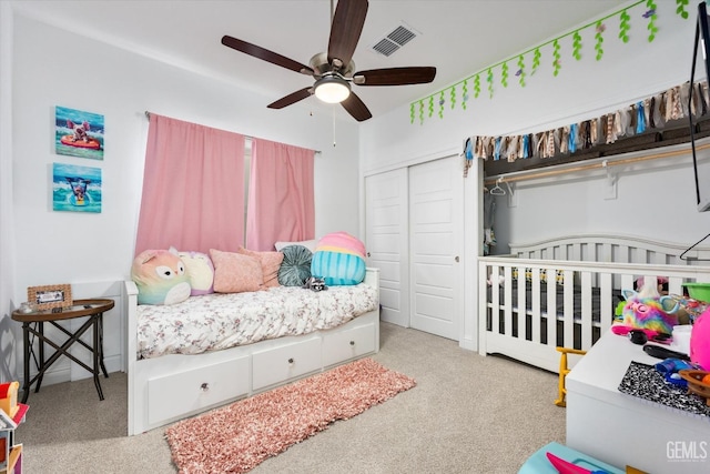 carpeted bedroom featuring a ceiling fan, visible vents, and a closet