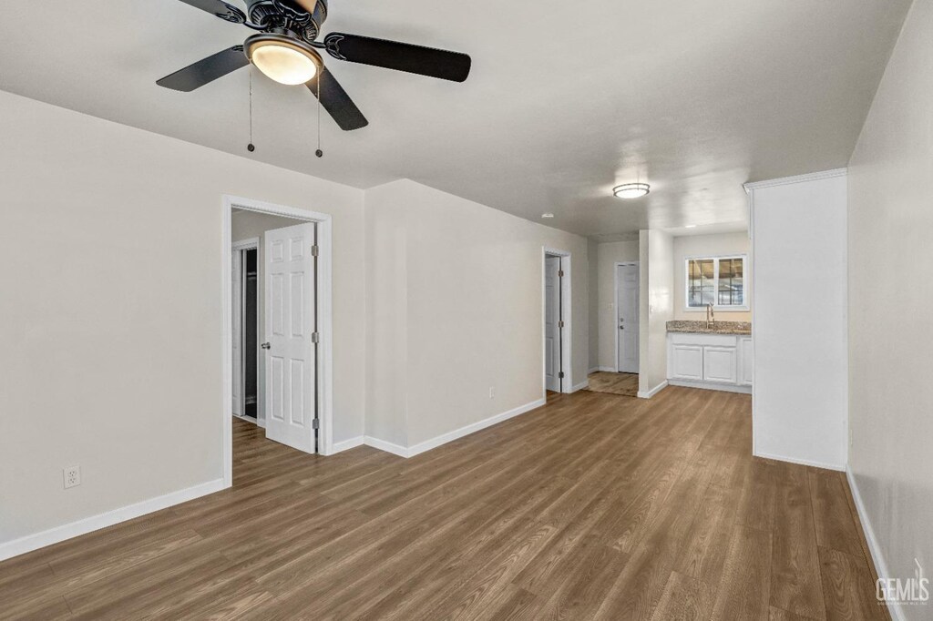 unfurnished bedroom with dark wood-type flooring, a closet, and ceiling fan