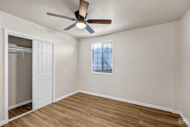 unfurnished bedroom with wood-type flooring, ceiling fan, and a closet