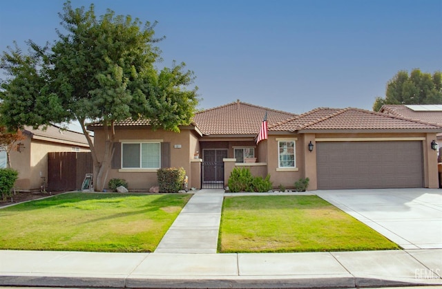 mediterranean / spanish-style house with a garage and a front lawn