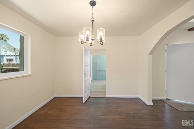 unfurnished dining area with dark hardwood / wood-style flooring and an inviting chandelier