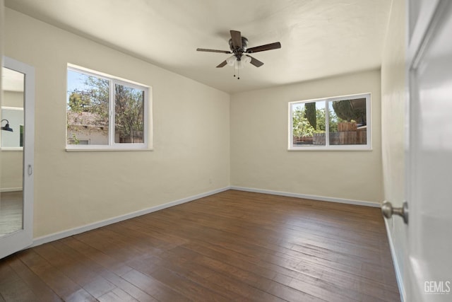 spare room with ceiling fan, a healthy amount of sunlight, and dark hardwood / wood-style floors