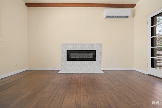 unfurnished living room featuring a wall mounted air conditioner, wood-type flooring, and beamed ceiling