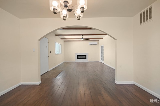 unfurnished living room with beam ceiling, a wall mounted AC, dark hardwood / wood-style flooring, and ceiling fan with notable chandelier