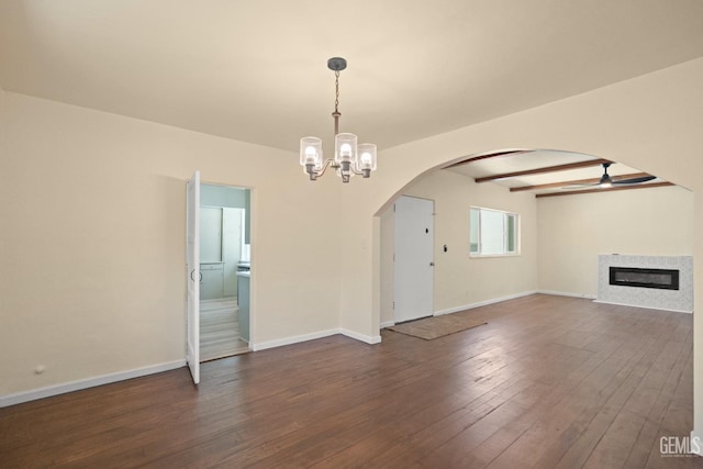 unfurnished living room featuring dark hardwood / wood-style flooring, ceiling fan with notable chandelier, and beam ceiling