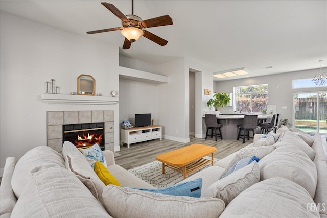 10809 Mirage Dr, Bakersfield, CA 93311 - living room featuring light wood-type flooring, a ceiling fan, a tile fireplace, and a chandelier