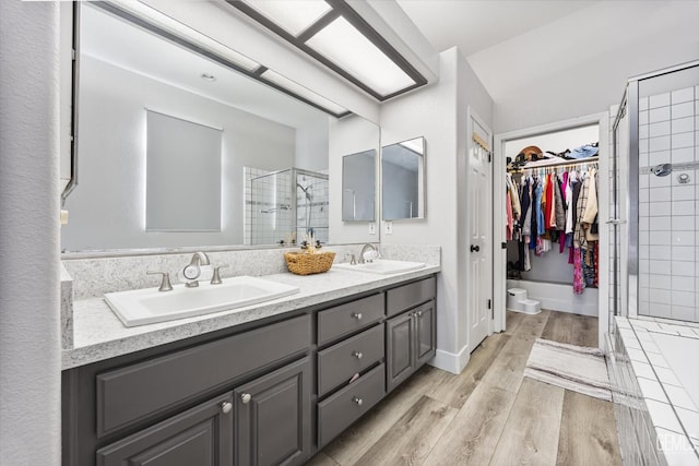 10809 Mirage Dr, Bakersfield, CA 93311 - bathroom with a shower stall, double vanity, a spacious closet, and wood finished floors