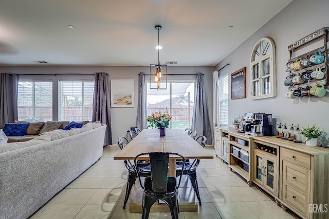 tiled dining room featuring a healthy amount of sunlight