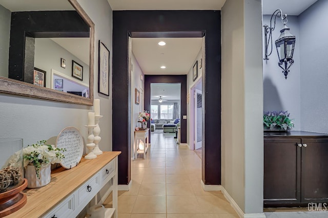 hallway featuring light tile patterned floors and baseboards