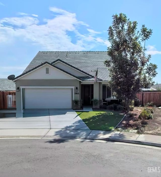 ranch-style home with a garage, driveway, and fence