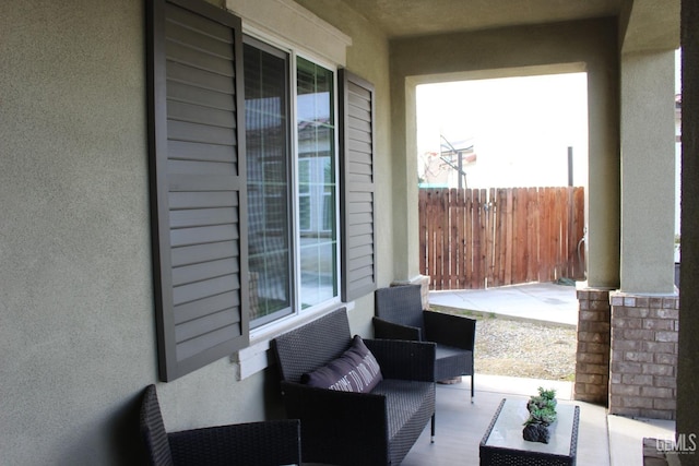 view of patio / terrace featuring covered porch and fence