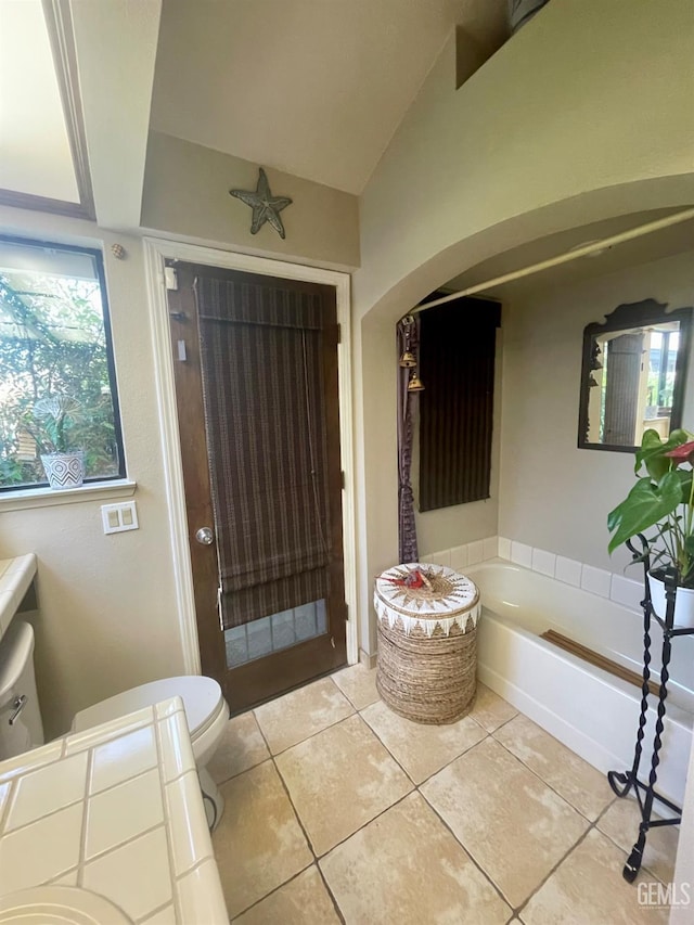 9125 Gleeson Ct, Bakersfield, CA 93311 - bathroom featuring toilet, tile patterned flooring, a bath, and vaulted ceiling