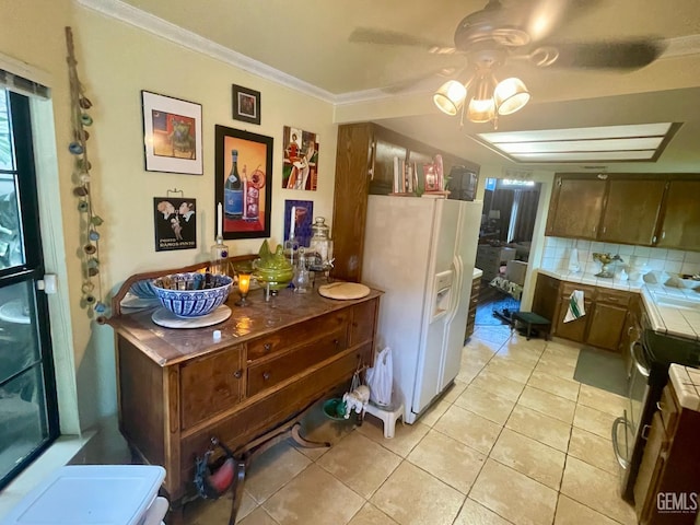 9125 Gleeson Ct, Bakersfield, CA 93311 - kitchen featuring white fridge with ice dispenser, light tile patterned floors, backsplash, tile countertops, and crown molding