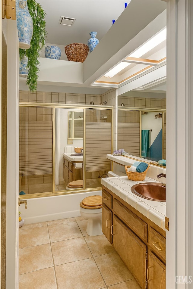 9125 Gleeson Ct, Bakersfield, CA 93311 - bathroom featuring vanity, tile patterned flooring, enclosed tub / shower combo, and a skylight