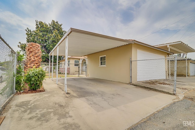 view of front of home with fence, a carport, and stucco siding