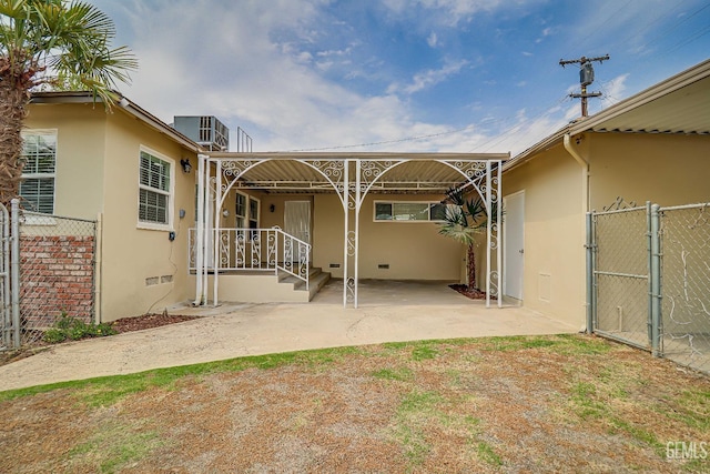 exterior space with stucco siding, a gate, central AC, fence, and crawl space