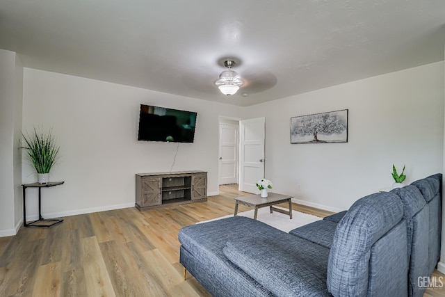 living area with ceiling fan, baseboards, and wood finished floors