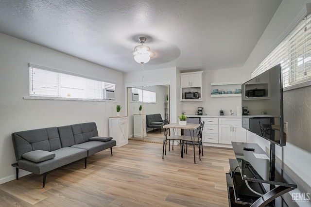 interior space with light wood finished floors, baseboards, and a textured ceiling