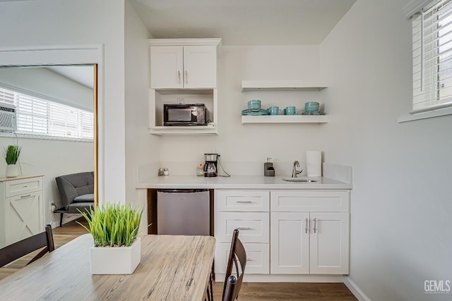 bar with a toaster, a sink, wood finished floors, baseboards, and fridge