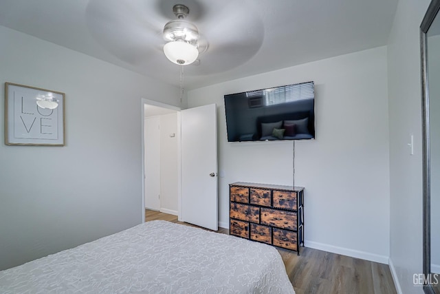 bedroom featuring baseboards and wood finished floors