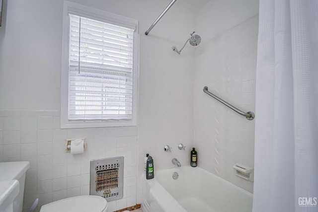 bathroom featuring toilet, tile walls, heating unit, and shower / bath combo with shower curtain