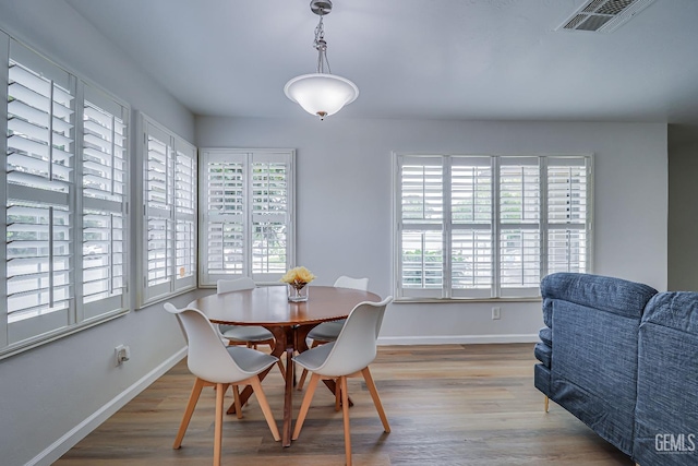 dining area featuring baseboards, visible vents, and wood finished floors