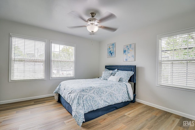 bedroom featuring a ceiling fan, light wood-style flooring, and baseboards