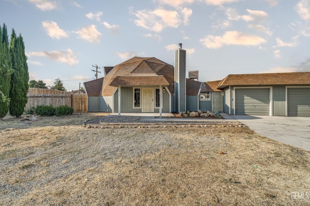 19701 Mesa Dr, Tehachapi, CA 93561 - view of front facade featuring concrete driveway, a chimney, a garage, and covered porch