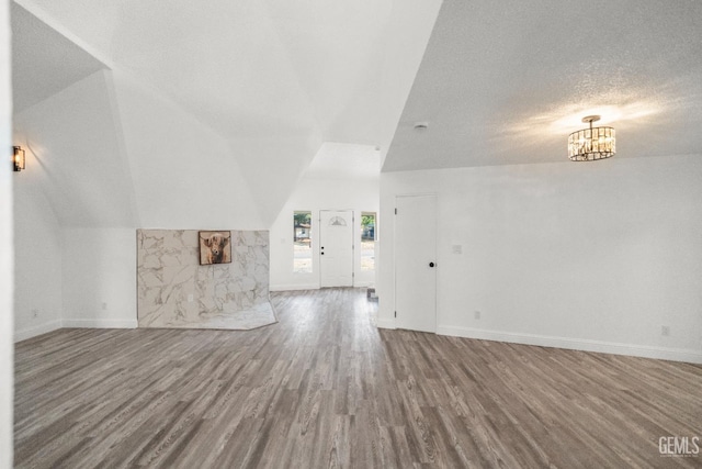 19701 Mesa Dr, Tehachapi, CA 93561 - unfurnished living room featuring wood finished floors, vaulted ceiling, and a chandelier