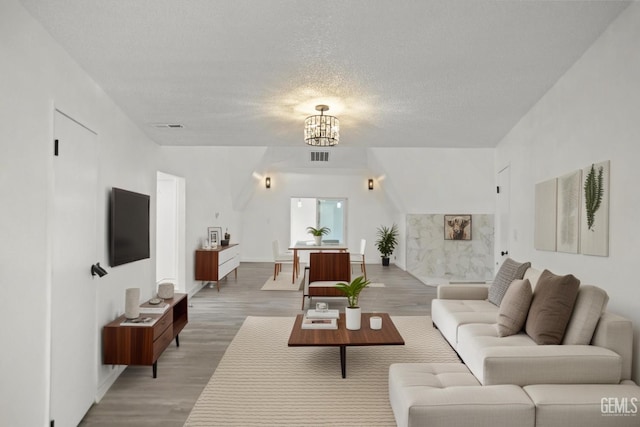 19701 Mesa Dr, Tehachapi, CA 93561 - living area featuring light wood-style floors, a chandelier, and a textured ceiling