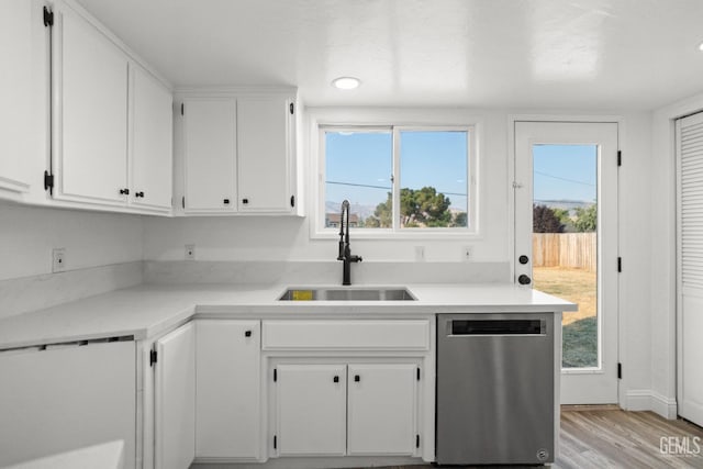 19701 Mesa Dr, Tehachapi, CA 93561 - kitchen with dishwasher, white cabinetry, light wood-style floors, and light countertops