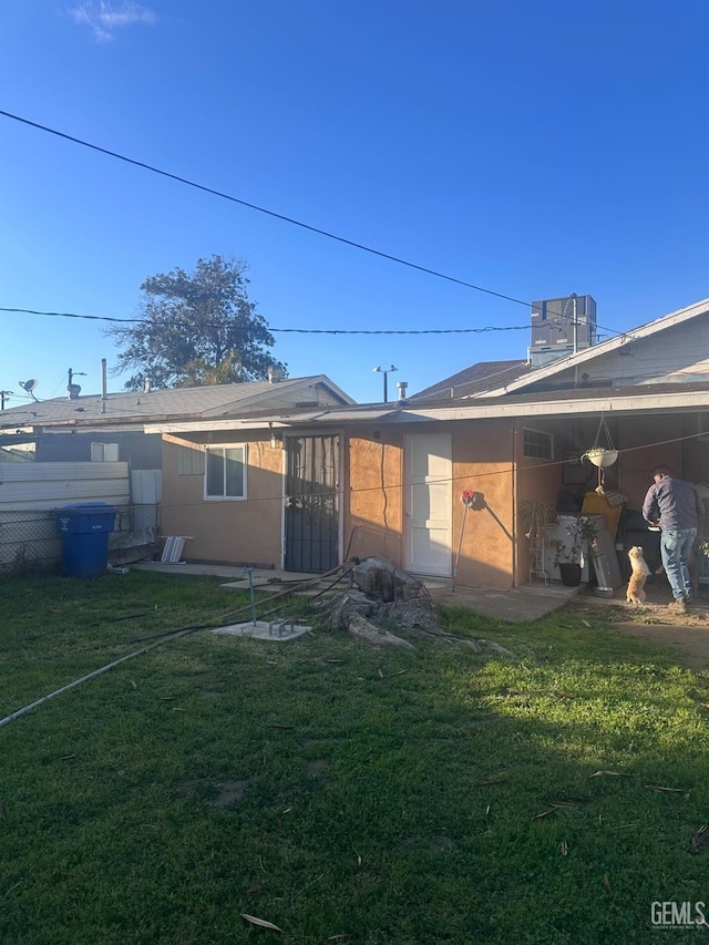 rear view of property with a yard