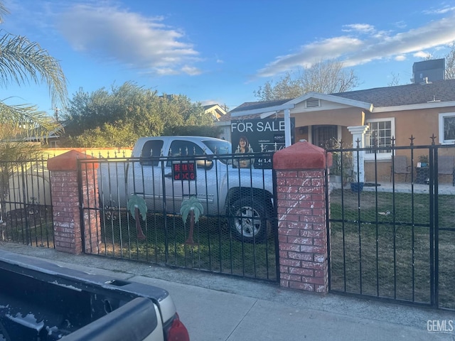 view of gate with a fenced front yard